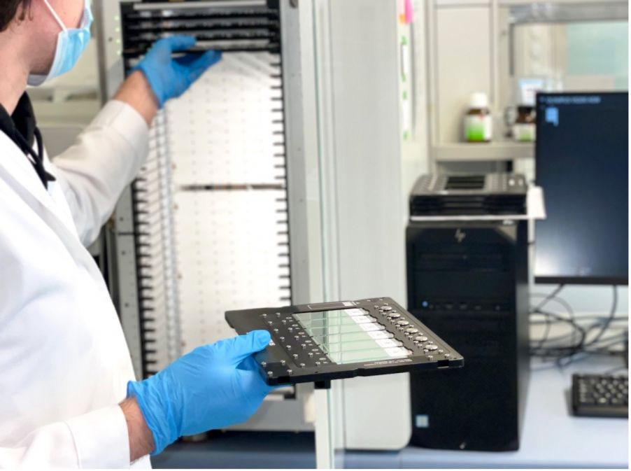 Un technicien dans un laboratoire d’analyse d’une entreprise de soins de santé pour animaux charge des lames d’échantillon dans le scanner de lames VS200